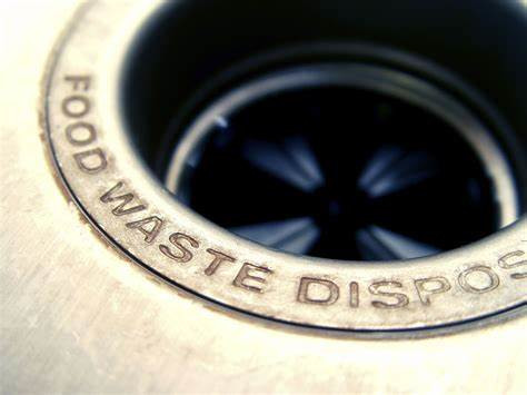 Technician repairing a leaking garbage disposal